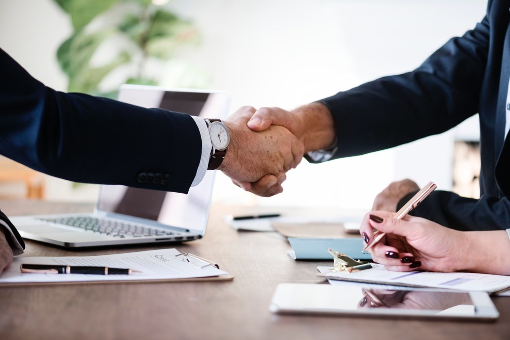 Insurance agents shaking hands with a client after enrollment